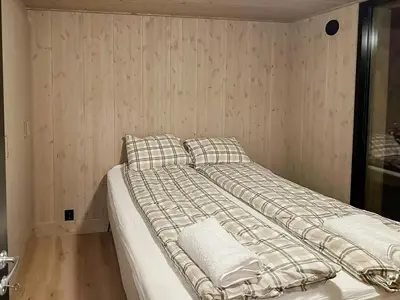 a bed in a room with a wall at Family Cabin With Picturesque View At Røn in Ron