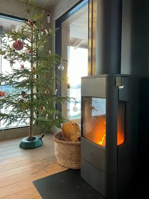 a living room with a fireplace and a christmas tree at Family Cabin With Picturesque View At Røn in Ron