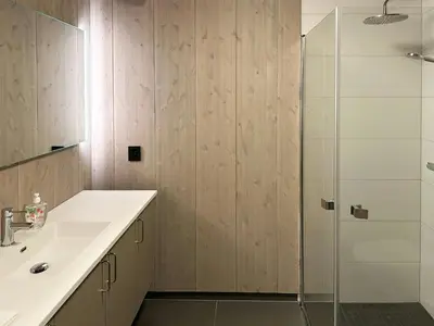 a bathroom with a sink and a glass shower at Family Cabin With Picturesque View At Røn in Ron