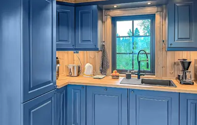 a blue kitchen with a sink and a window at 2 Bedroom Awesome Home In Engerdal in Kvisla