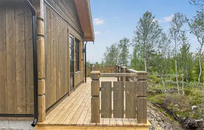 a wooden deck next to a house at 2 Bedroom Awesome Home In Engerdal in Kvisla