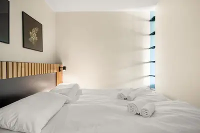 a white bed with two towels on top of it at Bergen Beds Apartment I 100 meters from Bryggen! in Bergen