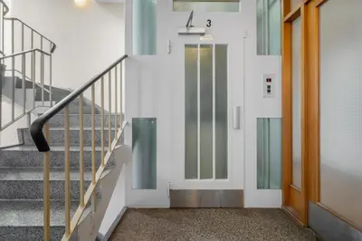 a hallway with a glass door and stairs at Bergen Beds Apartment I 100 meters from Bryggen! in Bergen