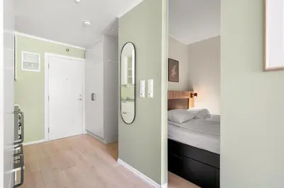 a white bedroom with a bed and a mirror at Bergen Beds Apartment I 100 meters from Bryggen! in Bergen