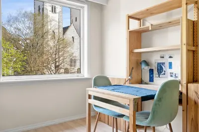 a table and chairs in a room with a window at Bergen Beds Apartment I 100 meters from Bryggen! in Bergen