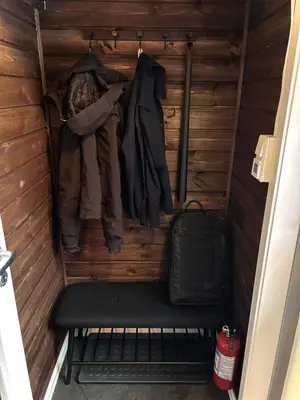 a small room with a bench and clothes at Modern cabin in amazing hiking area! in Gol