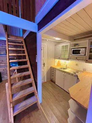 a kitchen with a staircase in a tiny house at Modern cabin in amazing hiking area! in Gol