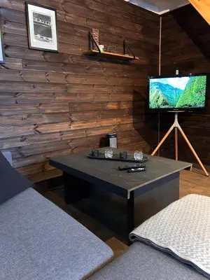 a living room with a table with a television on a wall at Modern cabin in amazing hiking area! in Gol