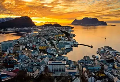 an aerial view of a city on the water at sunset at Ålesund Campus Apartments in Ålesund