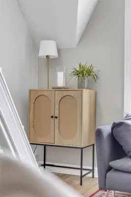 a wooden cabinet in a living room with a blue couch at Classic Bergen apartment peaceful space in the city center in Bergen