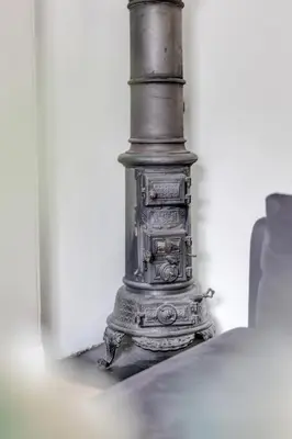 an old stove sitting in a corner of a room at Classic Bergen apartment peaceful space in the city center in Bergen