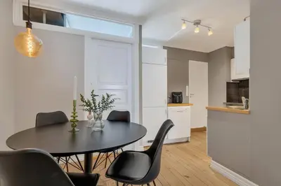 a kitchen and dining room with a table and chairs at Classic Bergen apartment peaceful space in the city center in Bergen