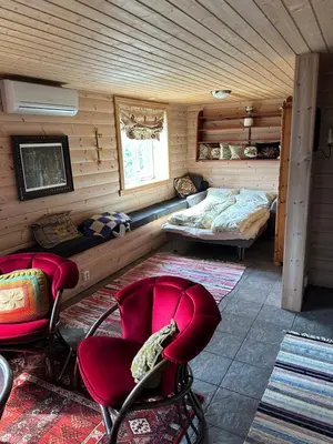 a room with two beds and chairs in a cabin at Panorama Stryn in Stryn