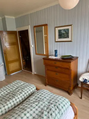 a bedroom with two beds and a dresser and a mirror at Panorama Stryn in Stryn
