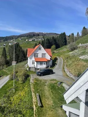 a car parked in front of a white house at Panorama Stryn in Stryn