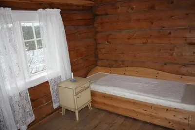 a bedroom with a bed and a window in a log cabin at Gravraakstuggu in Storneve
