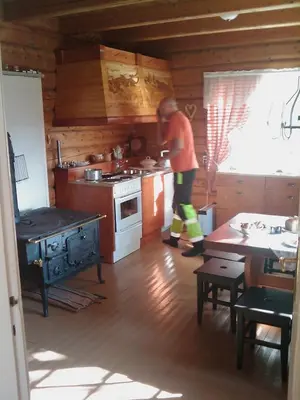 a man standing in a kitchen with a stove at Gravraakstuggu in Storneve