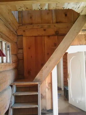 an attic room with stairs in a log cabin at Gravraakstuggu in Storneve