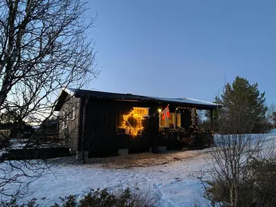 a house with lights in the window in the snow at Golsfjellet in Gol