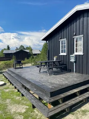 a picnic table and benches on a deck next to a building at Golsfjellet in Gol