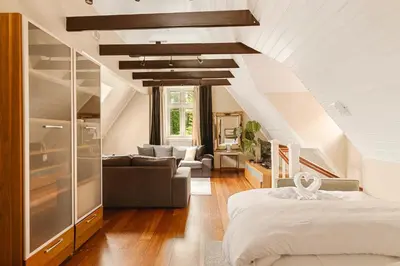 a bedroom with a bed and a living room at DINBNB Apartments l 50m to Bryggen l Multiple Apts l Balcony l View l Fireplace in Bergen