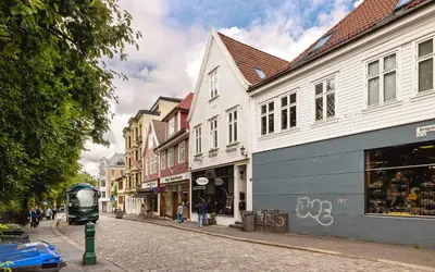 a city street with buildings and a bus on the street at DINBNB Apartments l 50m to Bryggen l Multiple Apts l Balcony l View l Fireplace in Bergen