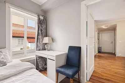 a bedroom with a bed and a desk and a chair at DINBNB Apartments l 50m to Bryggen l Multiple Apts l Balcony l View l Fireplace in Bergen