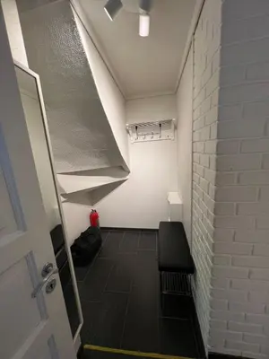 a room with a staircase and a white wall at Bergenshus rett ved Bryggen i Bergen in Bergen
