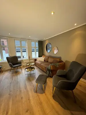 a living room with a couch and two chairs at Bergenshus rett ved Bryggen i Bergen in Bergen