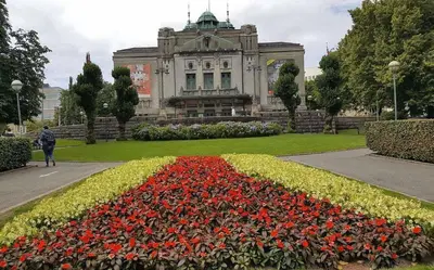 a building with a garden with flowers in front of it at Moderne Leilighet midt i Bykjernen Apt 1 in Bergen