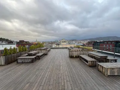 a boardwalk with benches and a view of a city at Modern three-room apartment, private terrace and roof terrace in Trondheim