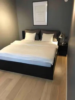 a bed with white sheets and pillows in a bedroom at Moderne Leilighet midt i Bykjernen in Bergen