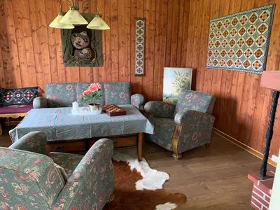 a living room with a couch and a table and chairs at Landlige Peru in Ringsaker