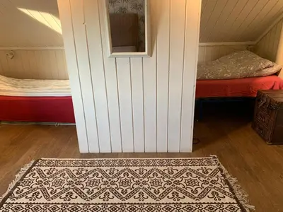 a room with a bed and a door with a rug at Landlige Peru in Ringsaker