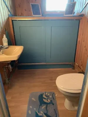 a bathroom with a toilet and a sink at Landlige Peru in Ringsaker