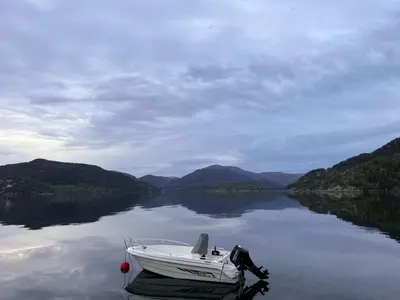 a boat sitting in the water on a lake at En Perle ved Masfjorden in Masfjorden