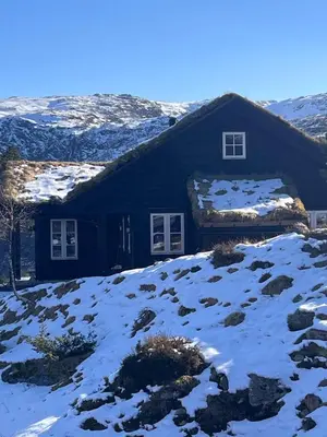 a house with snow on the roof of it at Drøm deg bort til fjells Velkommen til en perle av en hytte in Masfjorden