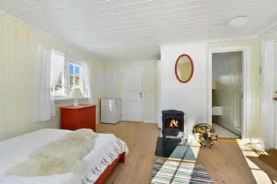 a bedroom with a bed and a wood stove at Atmospheric Log Cabin By Myllavannet
