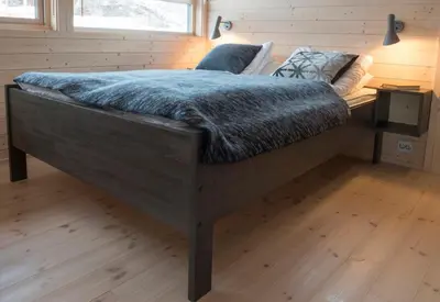 a bedroom with a large bed with a blue blanket at Sørbølhytta by Norgesbooking - cabin in Flå, close to Bjørneparken in Flå