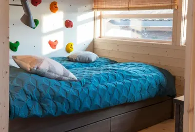 a bed in a tiny house with a window at Sørbølhytta by Norgesbooking - cabin in Flå, close to Bjørneparken in Flå