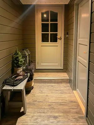 a porch with a white door and a bench at Large Familycabin In Fageråsen in Trysil