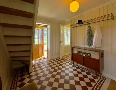 a hallway with a checkered floor and a staircase at Historic Croft With Views Over Lake Mjøsa in Ottestad
