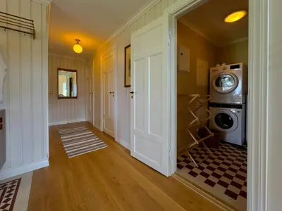 a hallway with a washing machine in a house at Historic Croft With Views Over Lake Mjøsa in Ottestad