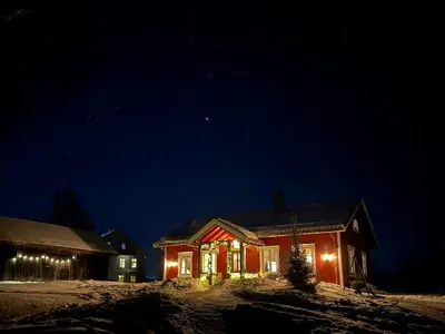 a house with christmas lights on it at night at Historic Croft With Views Over Lake Mjøsa in Ottestad