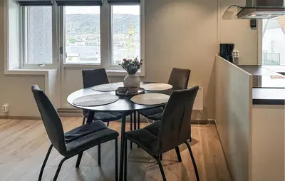 a kitchen with a table and chairs in a kitchen at 2 Bedroom Cozy Apartment In Laksevåg in Bergen