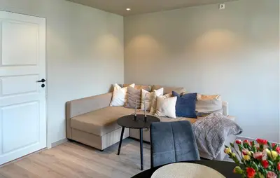 a living room with a couch and a table at 2 Bedroom Cozy Apartment In Laksevåg in Bergen