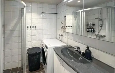 a bathroom with a sink and a washing machine at 2 Bedroom Cozy Apartment In Laksevåg in Bergen