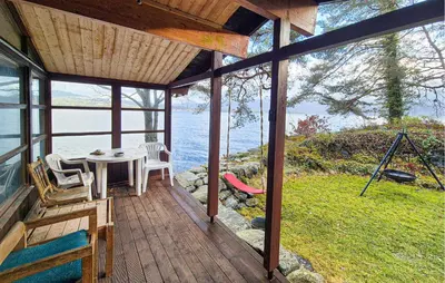 a porch of a house with a table and chairs at Nice Home In Hatlestrand With Wifi in Hatlestrand