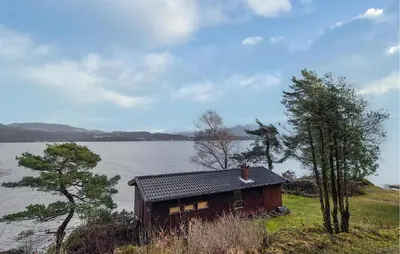 a small house on the side of a lake at Nice Home In Hatlestrand With Wifi in Hatlestrand