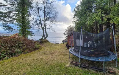 a tent on the side of a field next to the water at Nice Home In Hatlestrand With Wifi in Hatlestrand